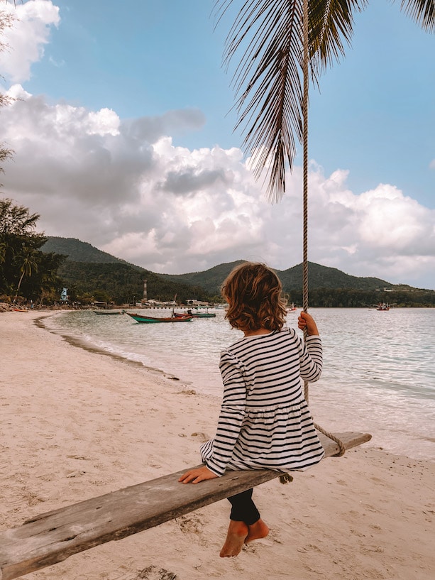 Ein Mädchen auf einer Schaukel an einem Strand in Thailand