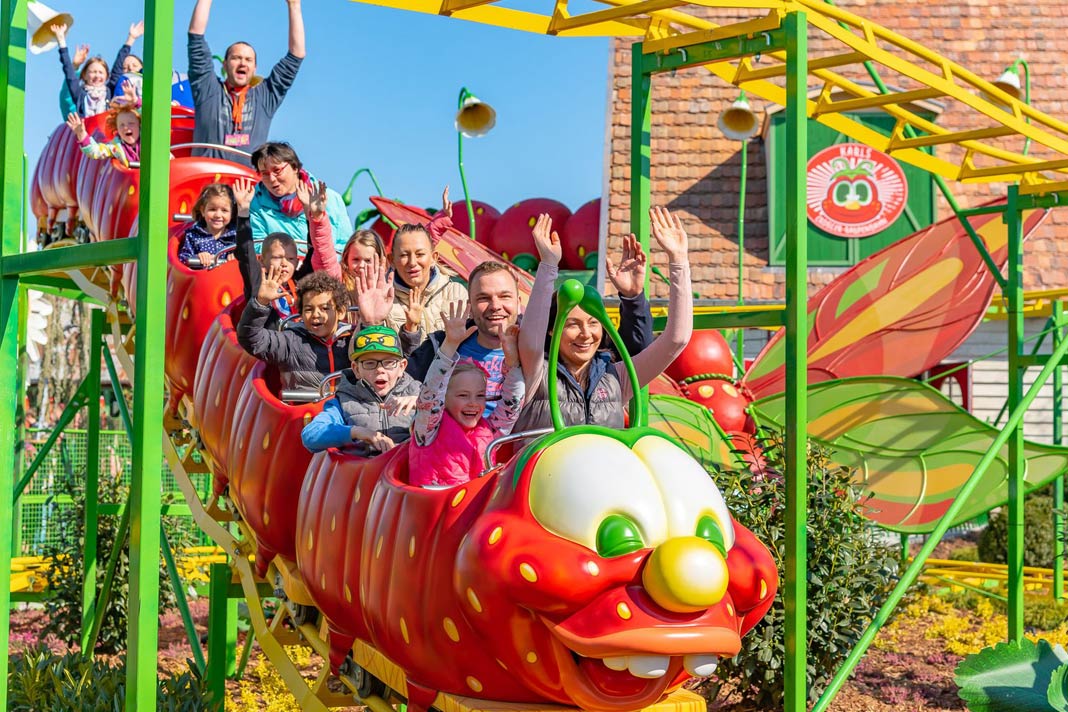 Kinder in einer Achterbahn, die wie eine Raupe aussieht