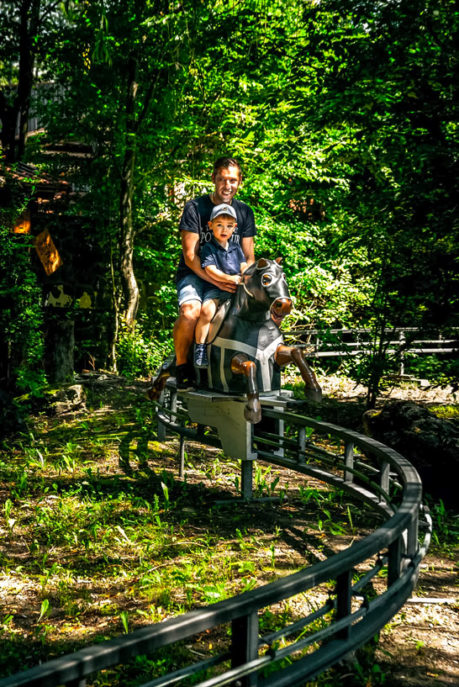 Kind und Vater auf der Pferdebahn im Schloss Thurn Freizeitpark